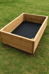 Bac rectangulaire en bois renforcé posé sur pelouse avec intérieur tapissé d’une toile noire