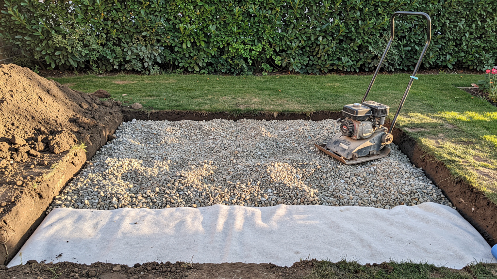 Fondation en grave compactée avec géotextile en place au jardin
