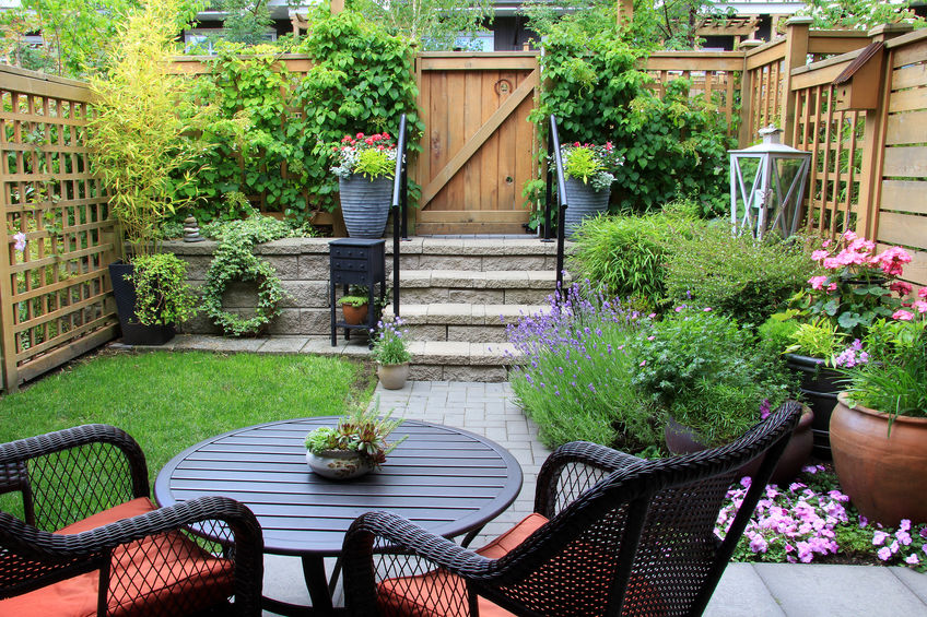 Patio fleuri avec table ronde, lavande et portillon en bois