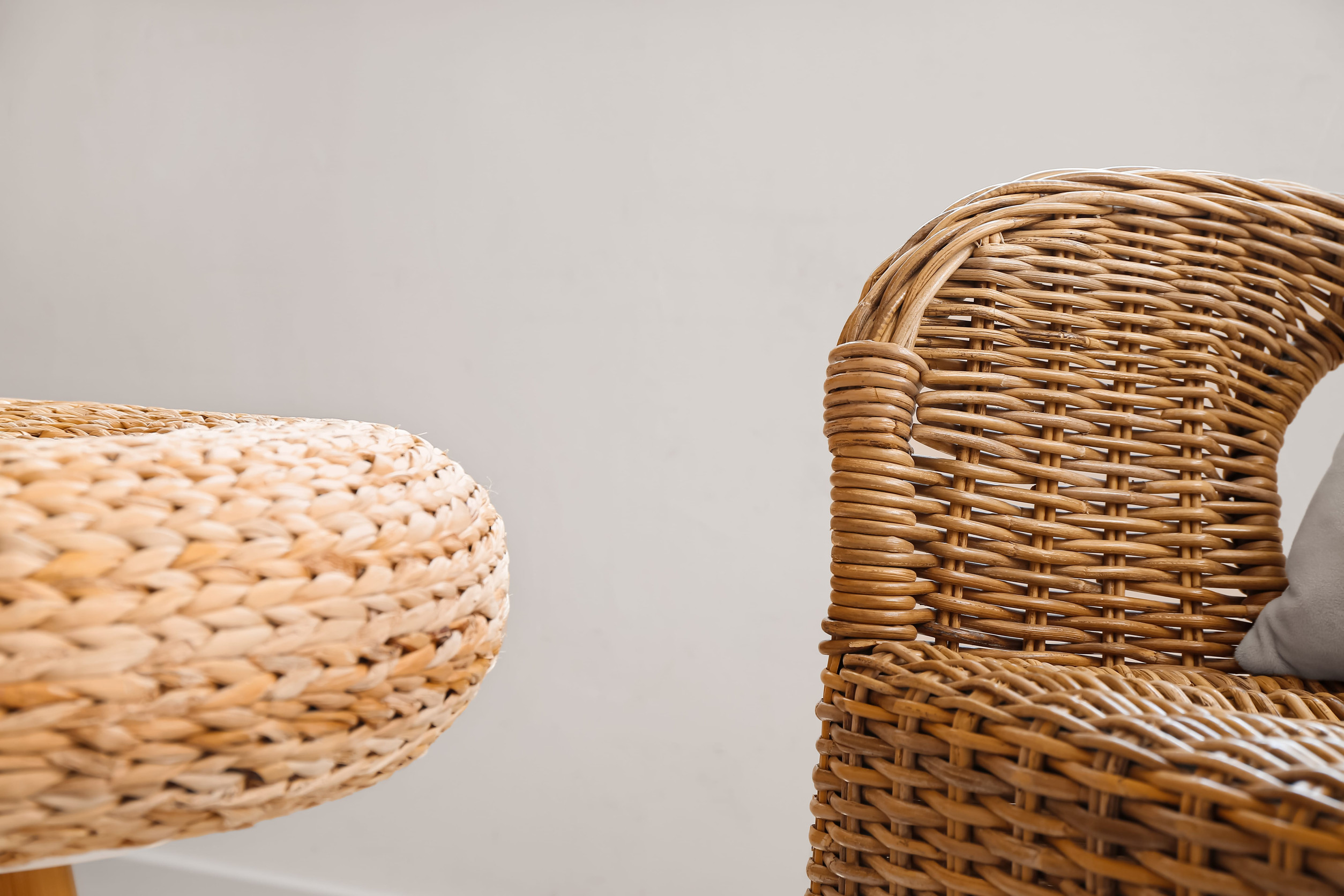 Accoudoir tressé et pouf, détail d’un salon de jardin en rotin