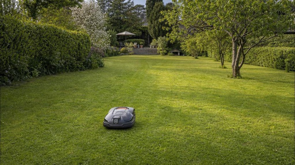 Robot rejoignant sa base au fond d’une grande pelouse
